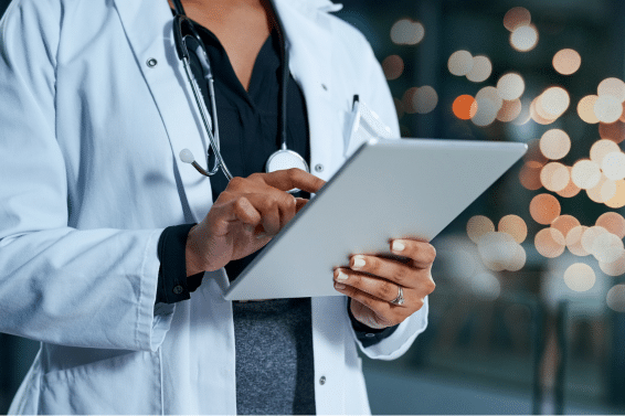 medical professional in white lab coat using tablet computer